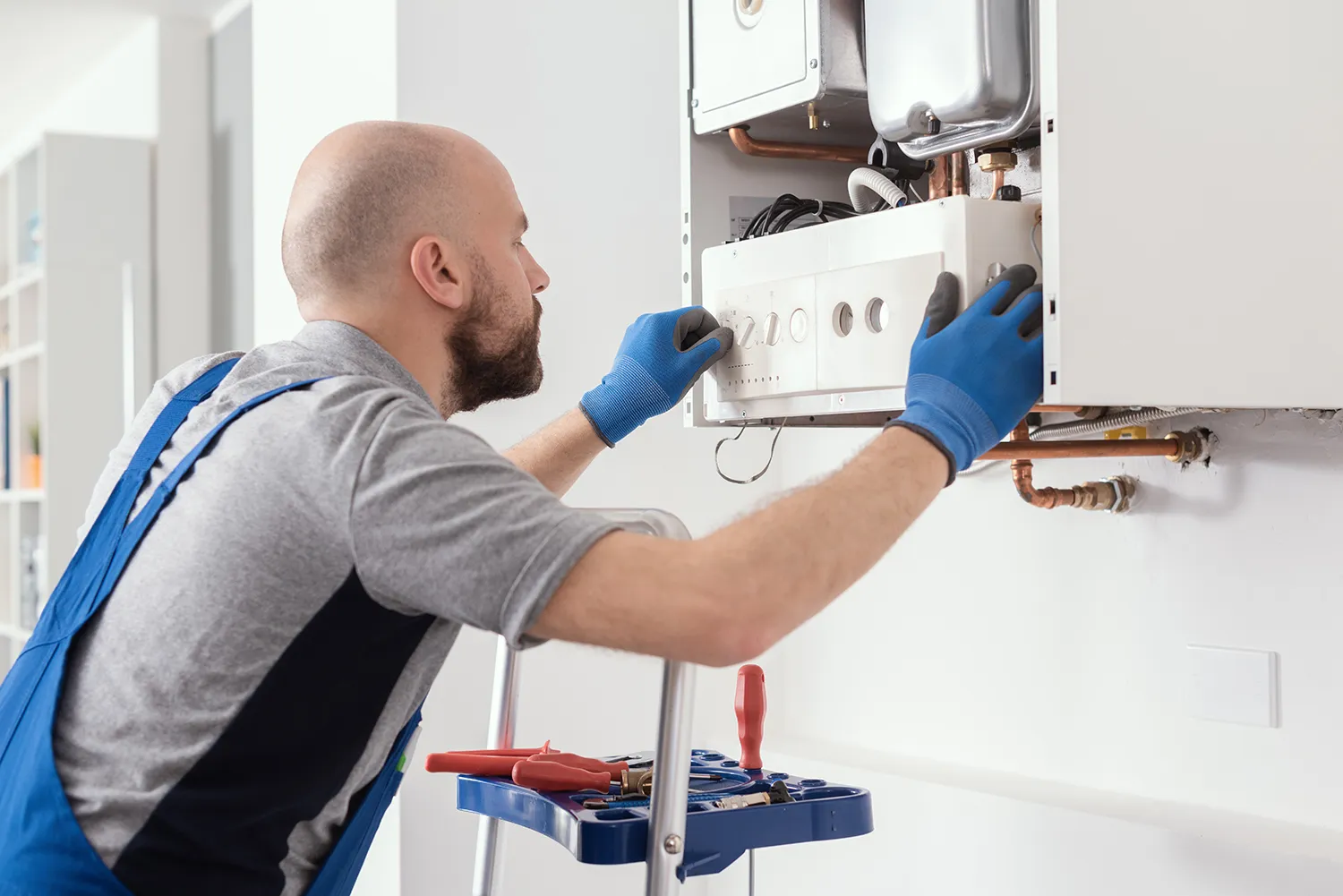 Technician repairing a wall-mounted boiler